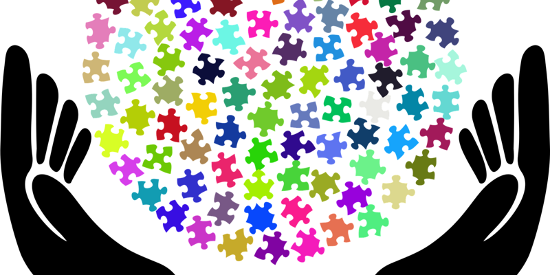 Hände sind wie eine Schale geformt und viele bunte Puzzleteile bilden eine Kugel in der Mitte