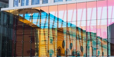 sich in einer Glasfassade spiegelnde Strukturen 