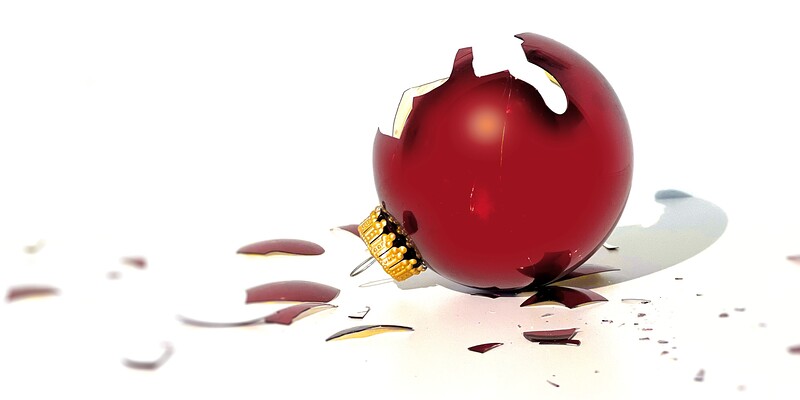 Eine liegende, zerbrochene rote Christbaumkugel.