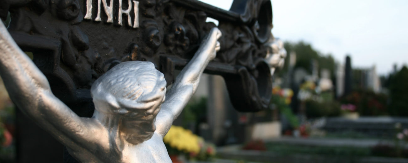 Trauerpastoral / © Diözese Eisenstadt/Walter Fiksz EIsenkreuz auf einem Friedhof mit dem Gekreuzigten und der Aufschrift INRI.